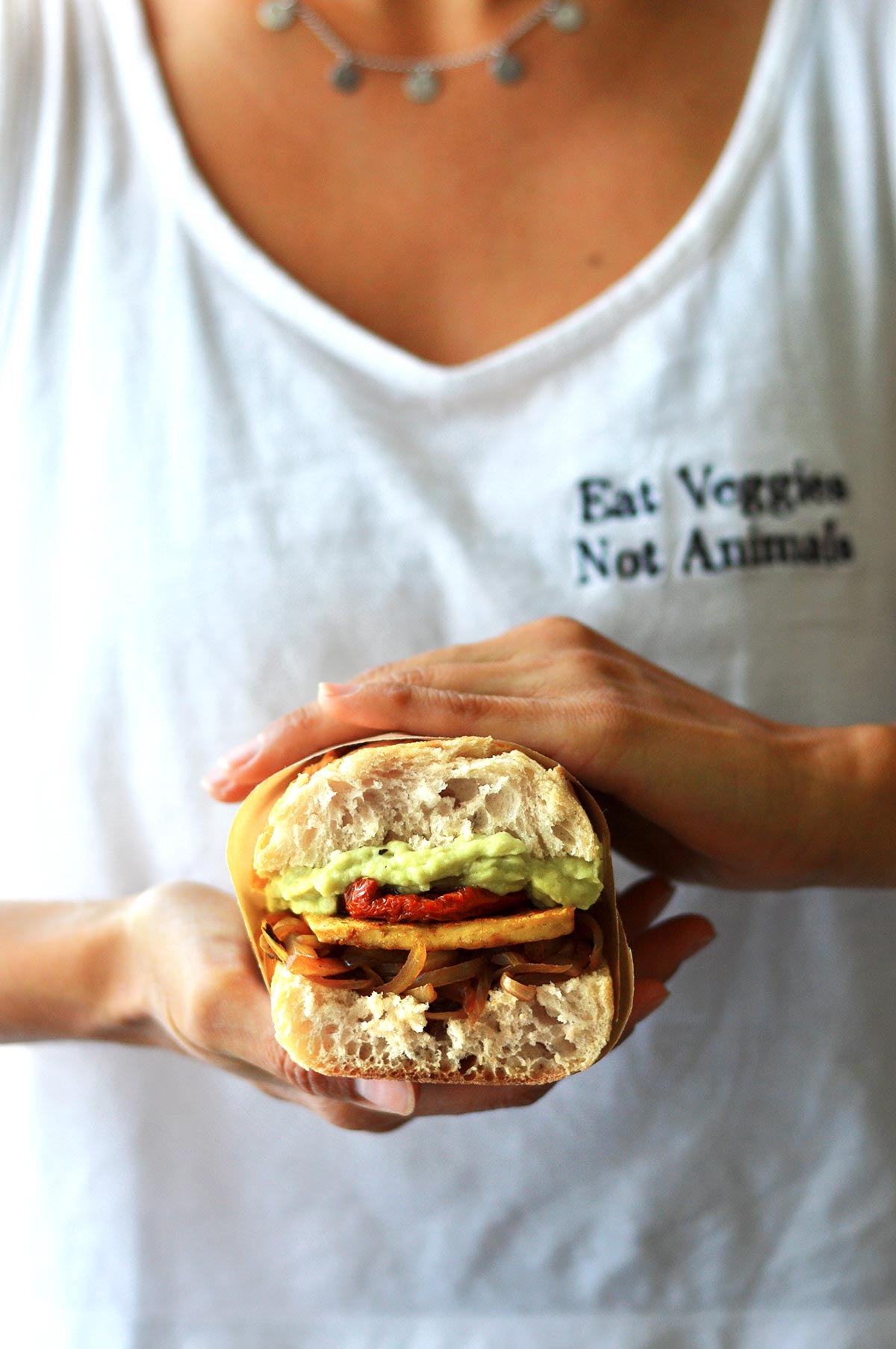 holding this delicious hearty vegan tofu sandwich