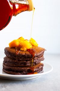 vegan chocolate pancakes drizzled with maple syrup